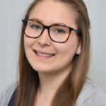 Foto einer Frau, die in die Kamera lächelt
