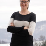 Ein Foto einer Frau, die in die Kamera lächelt