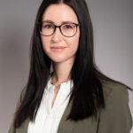 Ein Foto einer Frau, die in die Kamera lächelt