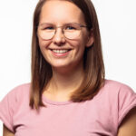 Eine Frau mit Brille posiert für ein Foto