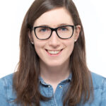 Eine Frau mit Brille posiert für ein Foto