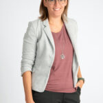 Eine Frau mit Brille posiert für ein Foto