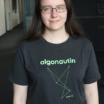 Frau in schwarzem T-Shirt mit 'Algonautin'-Logo