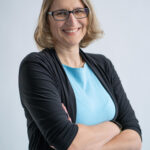 Foto von einer Frau mit blauem Hemd und Brille