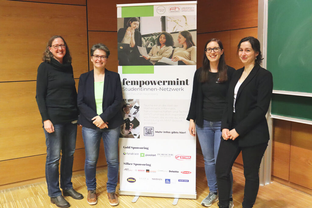 Vier Frauen stehen neben einem Banner