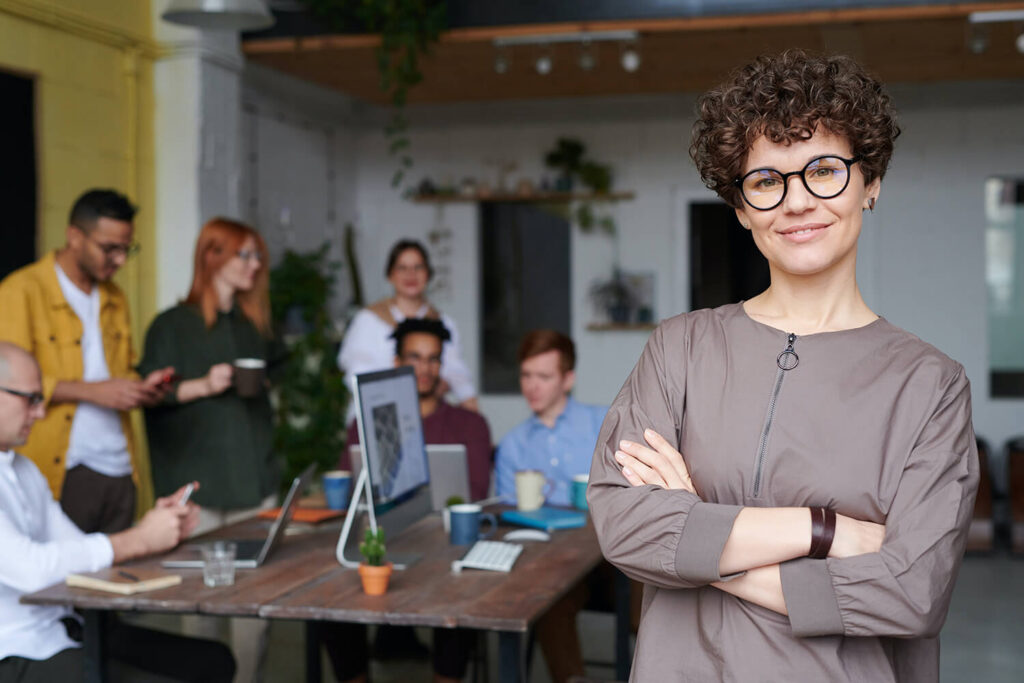 Eine Frau steht vor einer Arbeitsgruppe im Büro