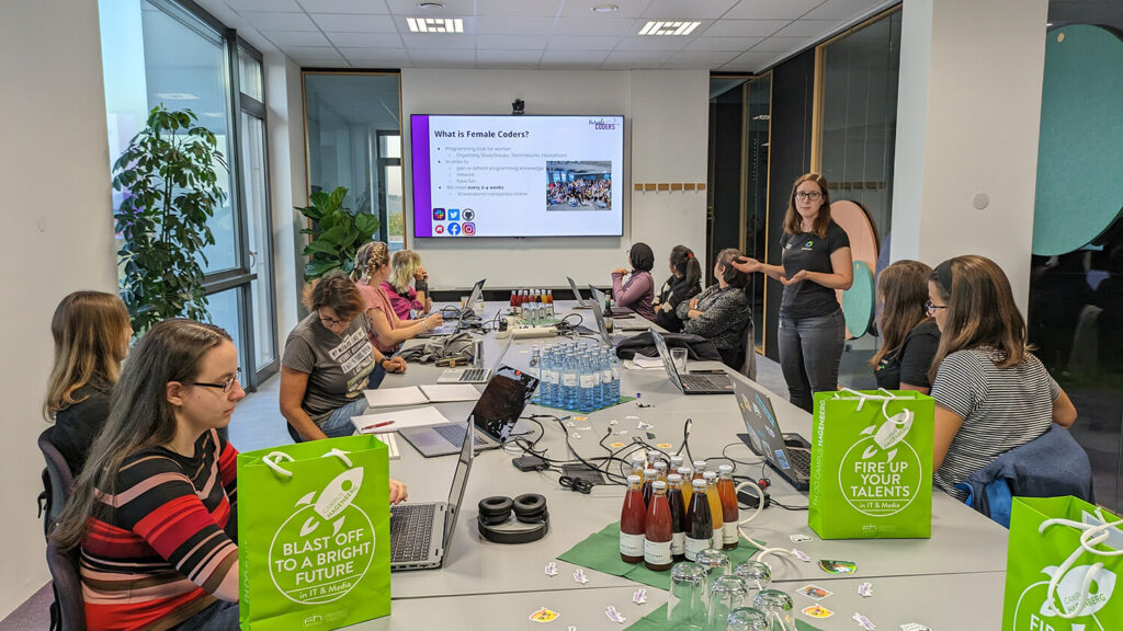 Eine Gruppe von Personen, die in einem Konferenzraum um einen Tisch sitzen
